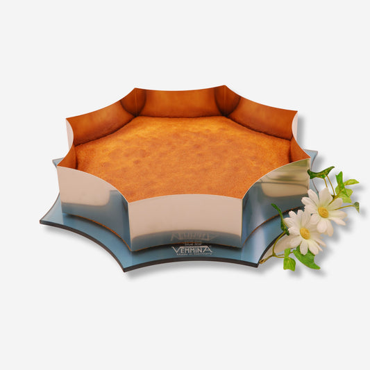 Merkur Cornwall Kuchenplatte in Sternform mit goldenem Kuchen und Blumenakzent.
